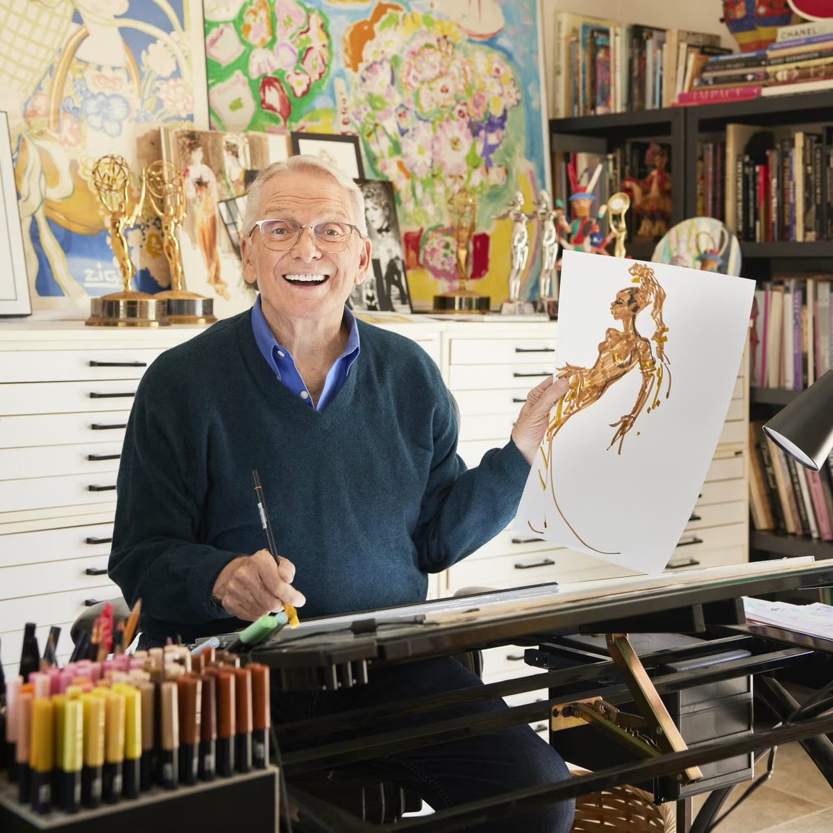Bob Mackie holding a costume sketch in his studio